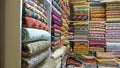 Traditional oriental multicolored fabricks stacked in store. Dubai market. Global village pavilion. Selective focus. Small depth