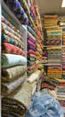Traditional oriental multicolored fabrics stacked in store. Dubai market. Global village pavilion. Selective focus. Small depth