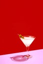 Traditional original drink. Glass with martini decorated with olives isolated over red background. Poster