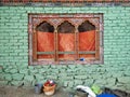 Traditional ornate window with arches on a green brick wall