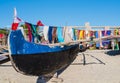 Traditional outrigger fishermen pirogue moored on Anakao coast with colorful pareo in the background, Indian Ocean, Madagascar Royalty Free Stock Photo