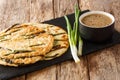 Traditional Pajeon Korean pancakes with green onions close-up on a slate board. horizontal