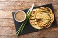 Traditional Pajeon Korean pancakes with green onions close-up on a slate board. Horizontal top view