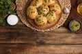 Traditional pampushka buns with garlic and herbs on wooden table, flat lay. Space for text Royalty Free Stock Photo