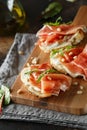 Traditional parma cured ham antipasto. Bruschetta set with Parma Ham and Parmesan Cheese. Small sandwiches with prosciutto,