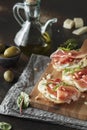 Traditional parma cured ham antipasto. Bruschetta set with Parma Ham and Parmesan Cheese. Small sandwiches with prosciutto,