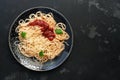 Traditional pasta spaghetti with tomato sauce, parmesan cheese and greens on a black stone background. Top view, flat lay,copy Royalty Free Stock Photo