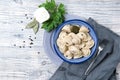 Traditional pelmeni, ravioli, dumplings filled with meat on wooden background, russian kitchen top view