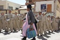 Traditional Peruvian woman passing by a group of schoolchildren