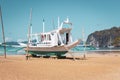 Traditional philippine boat called bangka on the beach, toned. Fishing boat on seacoast in Asia on sunny day with vignette. Royalty Free Stock Photo