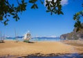 Traditional philippine boat called bangka on the beach with tree leaves on forefround. Fishing boat on seacoast in Asia. Royalty Free Stock Photo