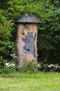 Traditional picturesque wooden bee hive in Slovenia, a tree trunk and painted bear