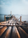 a traditional pier made of bamboo sticks, and a boat that is leaning on