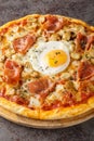 Traditional Pizza Bismarck made of egg, mozzarella, tomato, mushrooms and prosciutto closeup on the wooden board. Vertical Royalty Free Stock Photo