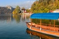 Traditional pletna boat on the waters of Lake Bled with Bled Castle cliff on the background, Upper Carniola, Slovenia. Colorful