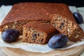 Traditional plum cake with nuts and cut into pieces on an wooden board close-up, selective focus