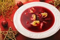 Traditional Polish christmas soup - red borscht soup with dumplings on white plate. Royalty Free Stock Photo