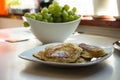 Traditional Polish pancakes on a white plate and green grapes on a kitchen counter Royalty Free Stock Photo