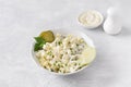 Traditional polish salad with apple, pickled cucumber, onion and mayonnaise on a light gray background