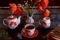 Traditional poppy seed bun with cup of tea and milk near poppies flowers and dishes with poppies ornaments. Delicious Royalty Free Stock Photo