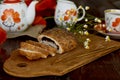 Traditional poppy seed bun with cup of tea and milk near poppies flowers and dishes with poppies ornaments. Delicious Royalty Free Stock Photo