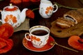 Traditional poppy seed bun with cup of tea and milk near poppies flowers and dishes with poppies ornaments. Delicious Royalty Free Stock Photo