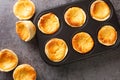 Traditional Portuguese cheesecakes called Queijadas de Sintra close-up in a baking dish. Horizontal top view