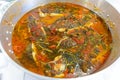 Traditional Portuguese fish stew, simmering in a large pot at a rustic restaurant.