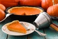 Traditional pumpkin pastry. Homemade bright colored pumpkin pie served with vintage sieves on blue background