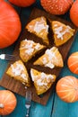 Traditional pumpkin pastry. Homemade triangular pumpkin scones with small pumpkins on blue background