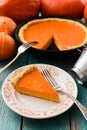 Traditional pumpkin pie. Piece of homemade bright pumpkin pie served on vintage plate on blue background