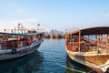 Traditional Qatari dhow boats with the skyline of Doha West Bay skyscrapers