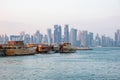 Traditional Qatari dhow boats with the skyline of Doha West Bay skyscrapers