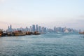 Traditional Qatari dhow boats with the skyline of Doha West Bay skyscrapers