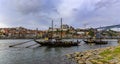 Traditional rabelo boats with barrels of port wine docked on Douro by famous Portuguese wine cellars in Porto, Portugal Royalty Free Stock Photo