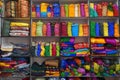 Traditional Rajasthan dress materials for sale in a cloth merchant shop in India. Colorful Jodhpur fabric street stall. Bandhej or