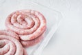 Traditional raw spiral pork sausages  on white background  in plastic pack   with space for text copyspace Royalty Free Stock Photo
