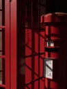 Traditional red British telephone box is situated next to a post