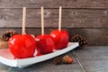 Traditional red candied apples against a rustic wood background