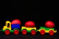 Traditional red eggs in plastic colorful car toy or locomotive Royalty Free Stock Photo
