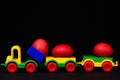 Traditional red eggs in plastic colorful car toy or locomotive Royalty Free Stock Photo