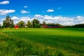 Traditional red farm house barn with white trim in open pasture with blue sky in Finland Royalty Free Stock Photo