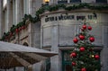 Traditional red and green Christmas tree decorations on ancient stone building. Red Christmas balls on conifer tree branches Royalty Free Stock Photo