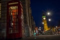 Traditional red phone booth or telephone box with the Big Ben in the background, possible the most famous English landmark, at