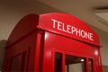 Traditional red telephone booth stands indoors as a symbol of London and the UK Royalty Free Stock Photo