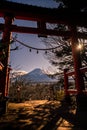 A traditional red torii gate and the Fuji mountain with snow cover at sunset Royalty Free Stock Photo