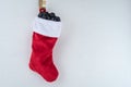 Traditional red and white plush Christmas stocking stuffed with coal shaped candy Royalty Free Stock Photo