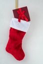 Traditional red and white plush Christmas stocking stuffed with a red wrapped present Royalty Free Stock Photo