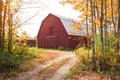 Driveway to a red wooden barn in the countryside of New England on a sunny autumn day Royalty Free Stock Photo