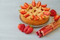 Traditional rhubarb strawberry pie on the gray kitchen background. Veggie berries tart decorated with organic fresh strawberries